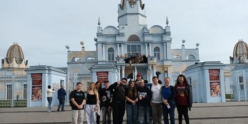 Die Reisegruppe mit 12 Personen steht vor dem Haupteingang des Freizeitparks