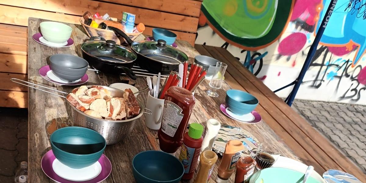 Tisch mit Speisen und Getränke, im Hintergrund Graffitis