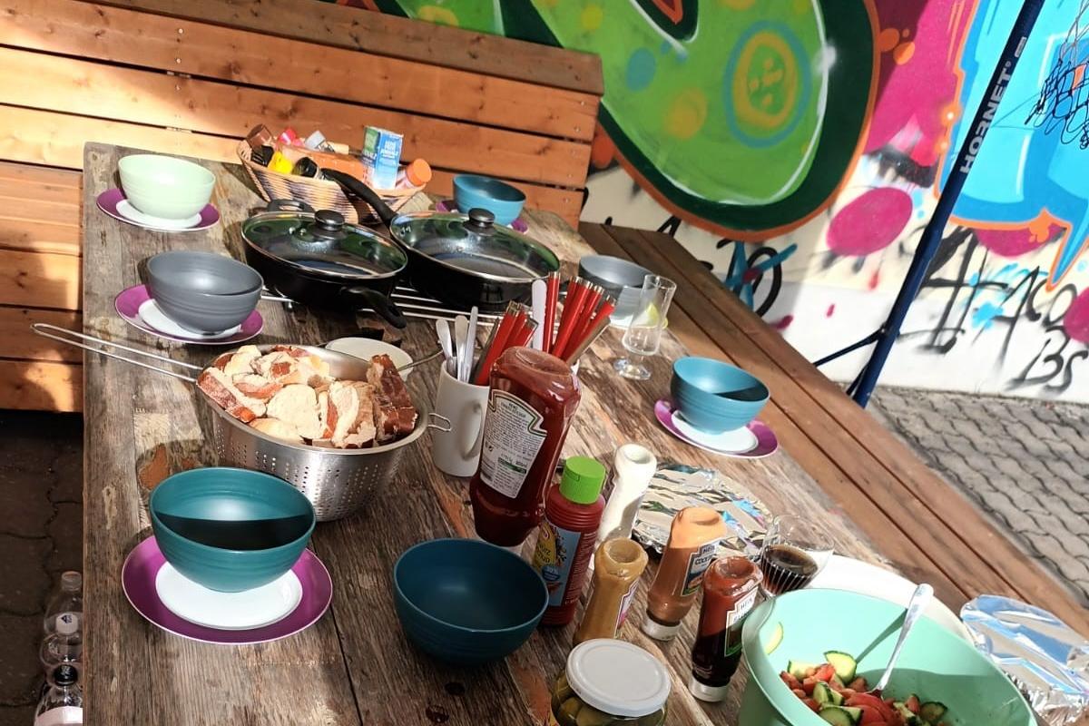 Tisch mit Speisen und Getränke, im Hintergrund Graffitis