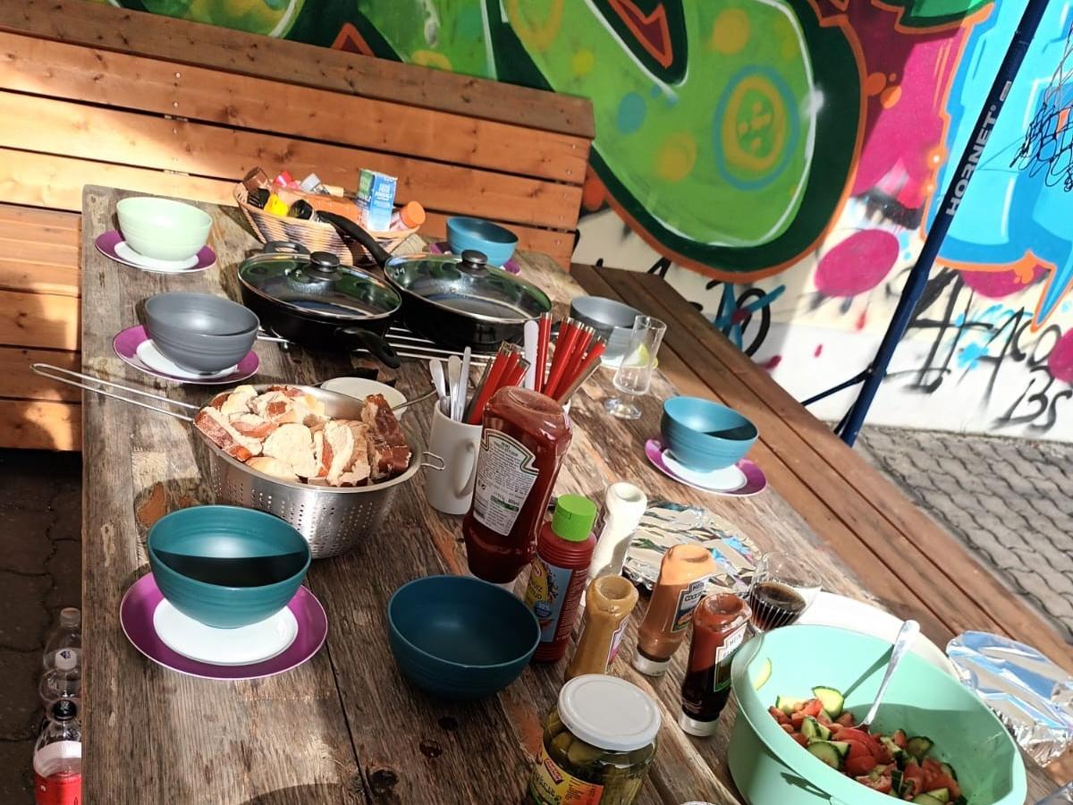 Tisch mit Speisen und Getränke, im Hintergrund Graffitis